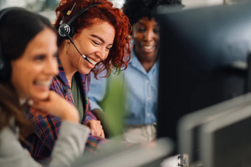 a customer support operator is sitting at call center in the office and contacting client a woman is having headset and talking to a client online a friendly operator is solving technical problems