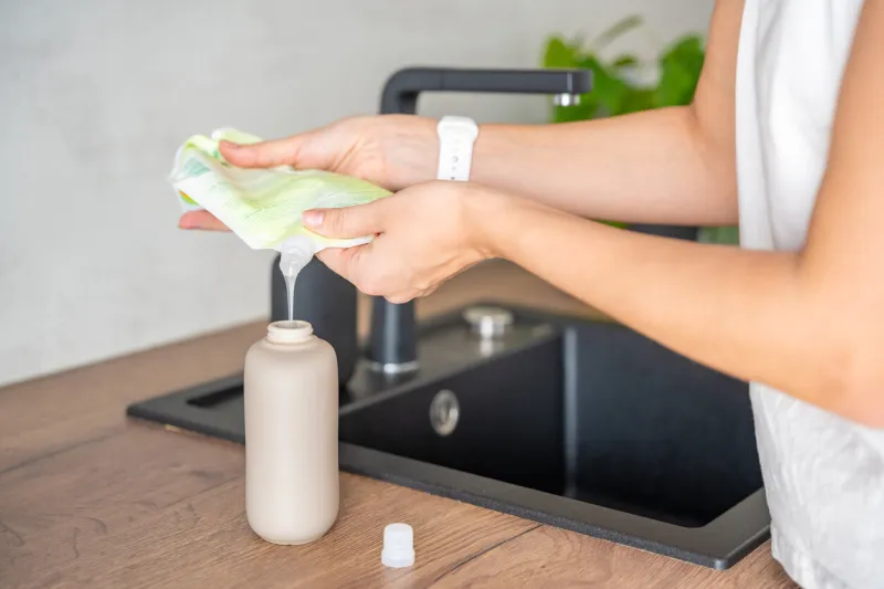 woman pours soap or detergent from recycled packaging into a reusable bottle eco-friendly lifestyle concept high quality photo