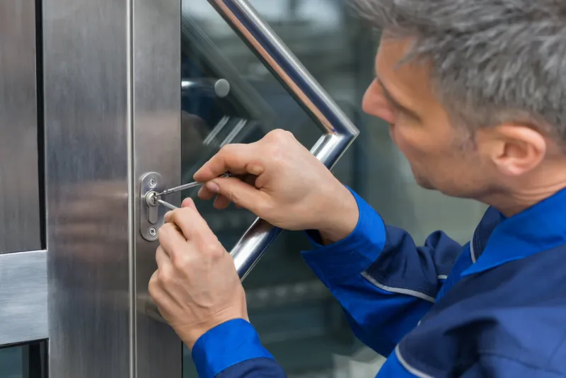 mature male lockpicker fixing door handle at home