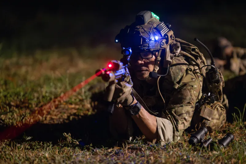 soldiers in camouflage uniforms aiming their rifles ready to fire during military night operation