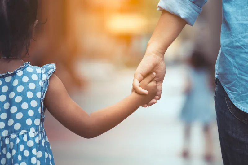 mother and daughter holding hand together with love in vintage color tone