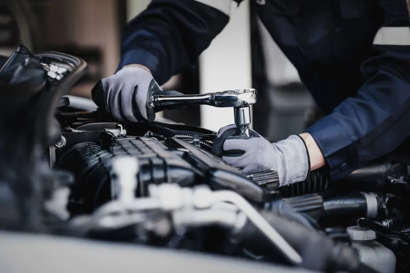 professional mechanic working on the engine of the car in the garage car repair service the concept of checking the readiness of the car before leaving