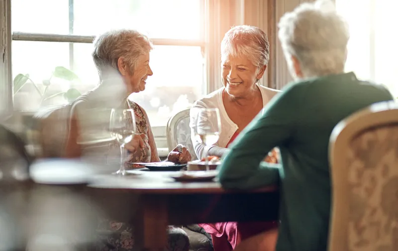 senior women, friends and smile in restaurant for wine, vacation and retirement together with happy elderly people, reunion and relax in diner for drinks, holiday and social celebration with memory