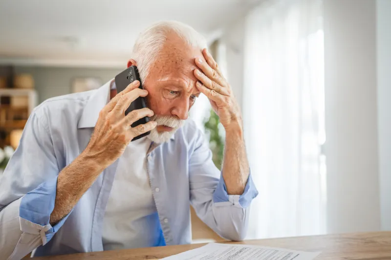 senior man sit at home have a phone call while receive bad report at envelope