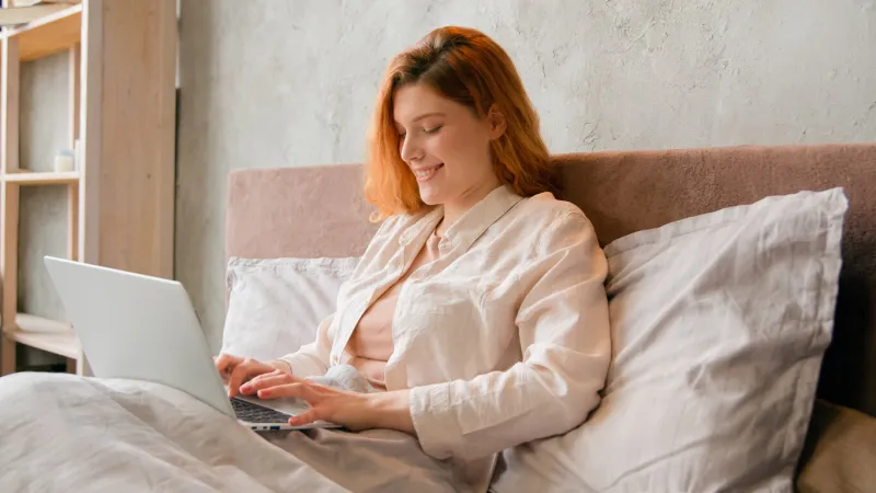caucasian woman in tranquil morning freelancer businesswoman student girl in bed after wake up sleeping typing computer laptop working distant from home bedroom smiling chatting online internet addict high quality 4k footage