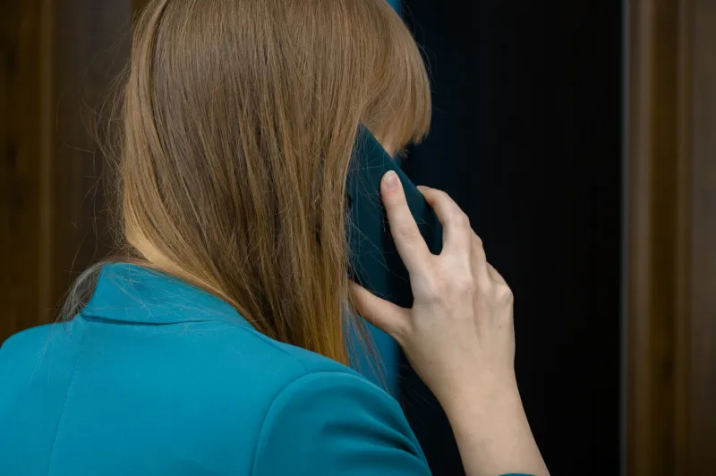 call a woman holds a mobile phone to her ear
