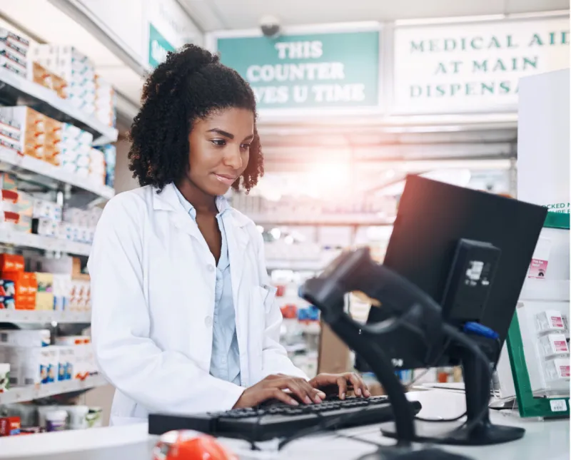 pharmacy, healthcare and black woman with medicine, working and inventory with keyboard in store for pills shop, person and computer for process of prescription, online and typing of employee in job