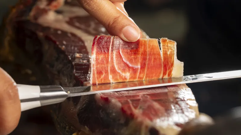iberian ham acorn fed iberico ham spanish ham 5j perfect slice of iberian ham cut with a knife by a professional ready to eat selective focus and blur background