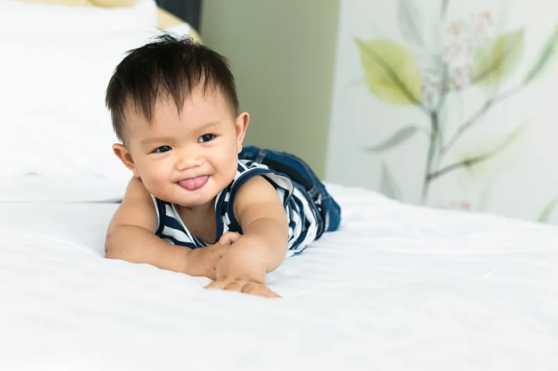 cute baby boy lying on bed at home