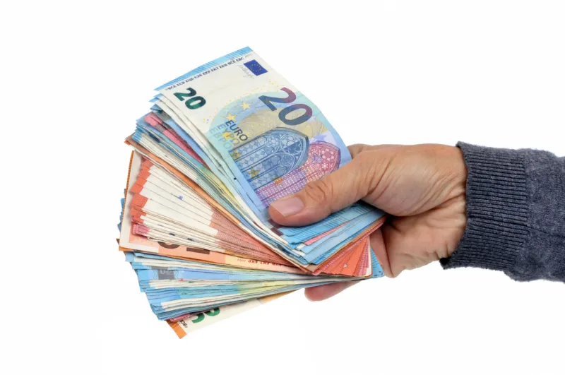 close-up hand holding euro banknotes on a white background