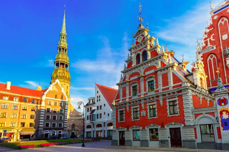 city hall square with house of the blackheads and saint peter church in old town of riga in the evening, latvia