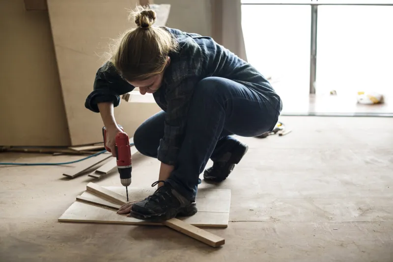 a carpenter using a drill on a wood