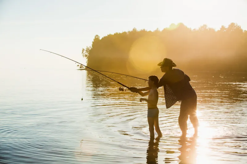 fisherman and son at lake on sunset