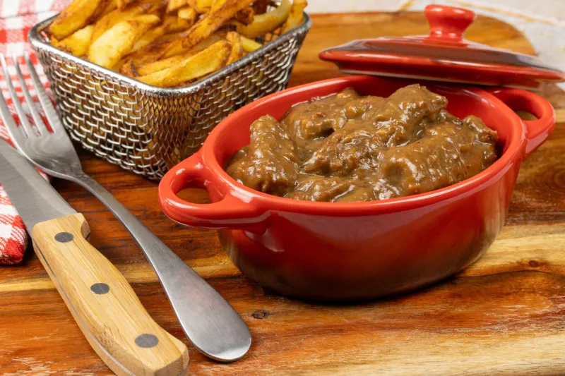 dish of flemish carbonade and fries on a table