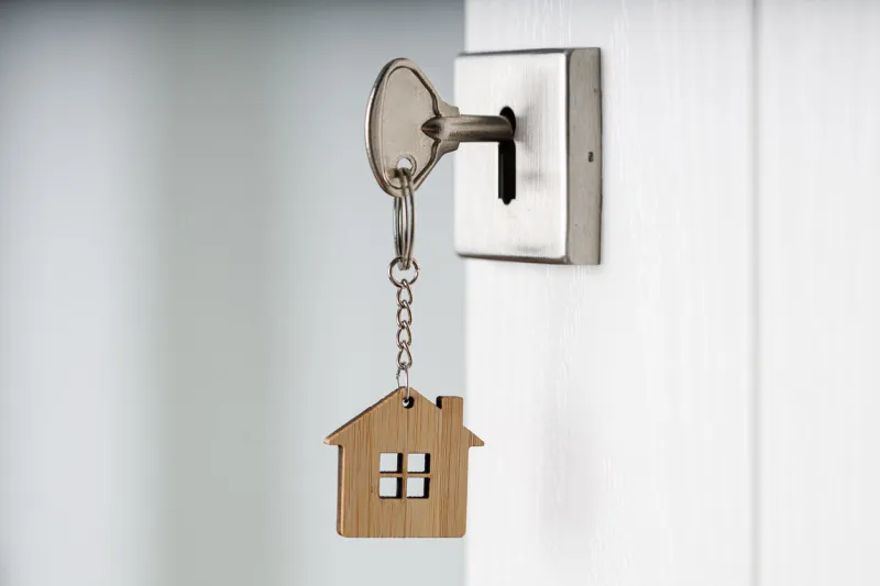 room key and a house-shaped keychain an open door real estate investment concepts