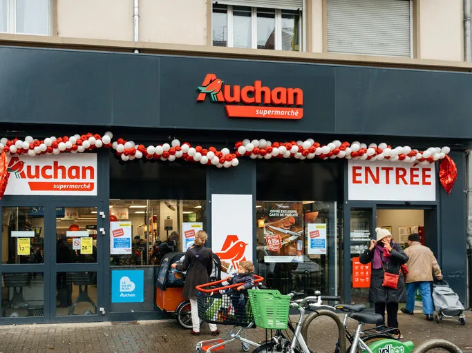 strasbourg  new auchan supermarket entrance in french neighborhood on a winter snow day with customers exiting the entrance of the store