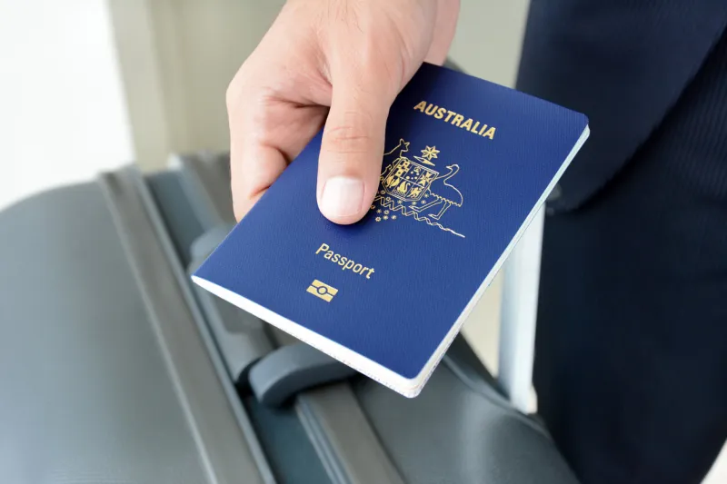 hands giving passport (of australia)