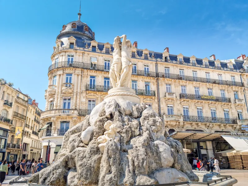 montpellier, france - 22 may 2023  people walking in the place de la comedie square by the three graces fountain the place is the focal point of the city