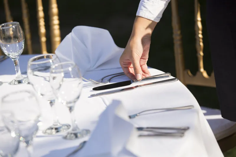 waiter setting the table in restaurant