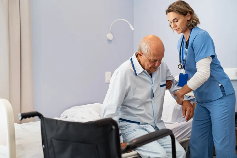 nurse helping senior patient at clinic