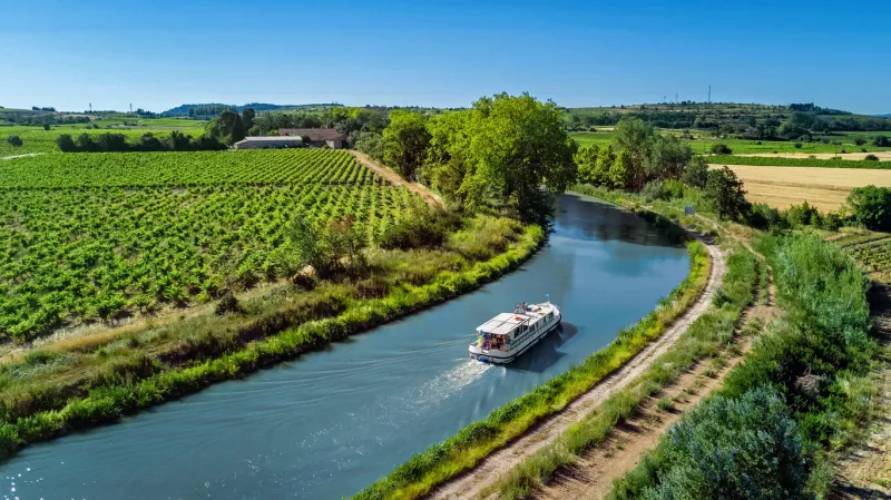 houseboat in canal du midi aerial drone view from above, family water travel by boat, vacation in southern france