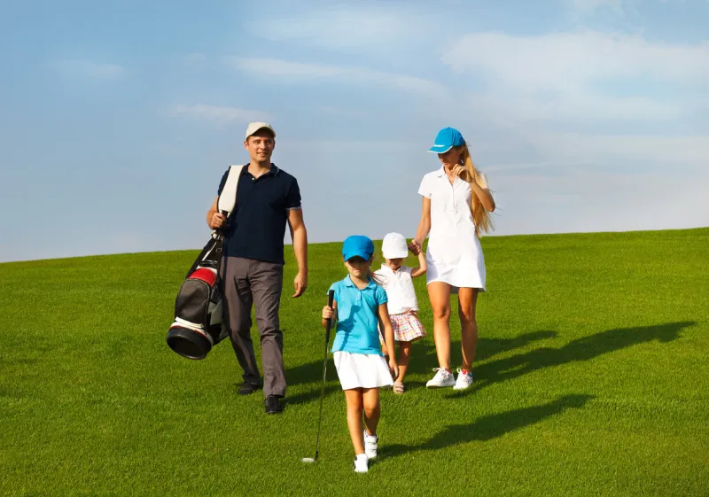 family of golf players walking at the course