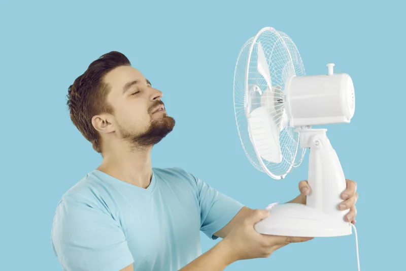 Homme devant ventilateur