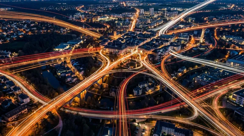 Une vue aérienne de la ville de Luxembourg avec des lignes lumineuses représentant le flux des trava