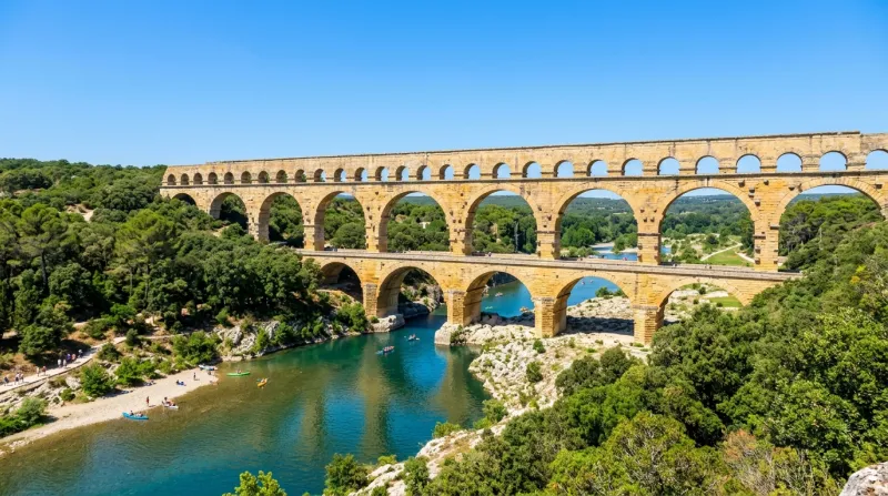 Une photo du Pont du Gard sous un soleil éclatant et un ciel bleu sans nuages