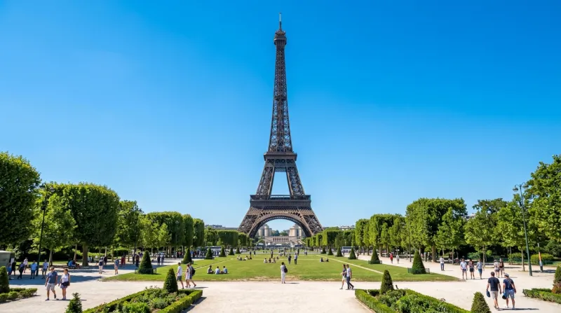 Une photo de la tour Eiffel sous un ciel bleu dégagé et un soleil éclatant
