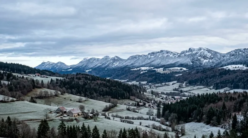 Paysage du Doubs avec les crêtes jurassiennes enneigées par temps froid.