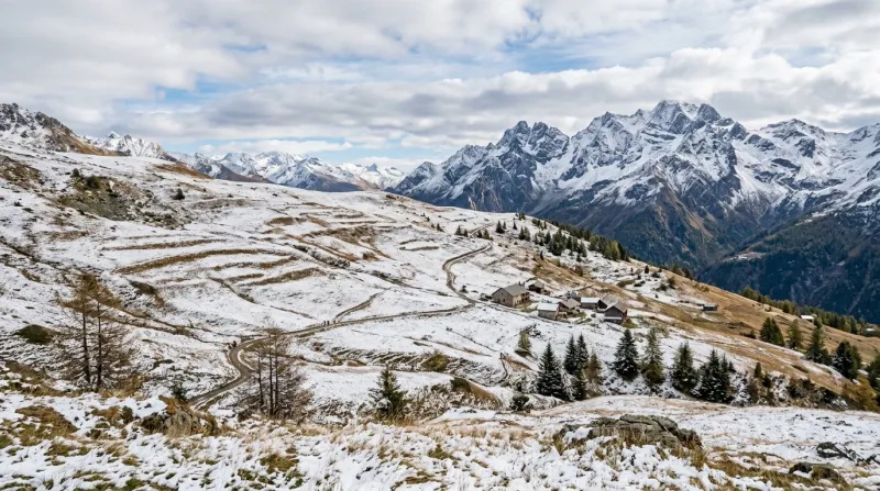 Un paysage de moyenne montagne avec un premier saupoudrage de neige sur les alpages et des arbres en