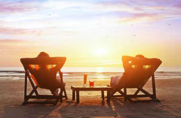 couple heureux profiter du coucher de soleil de luxe sur la plage pendant les vacances d'été