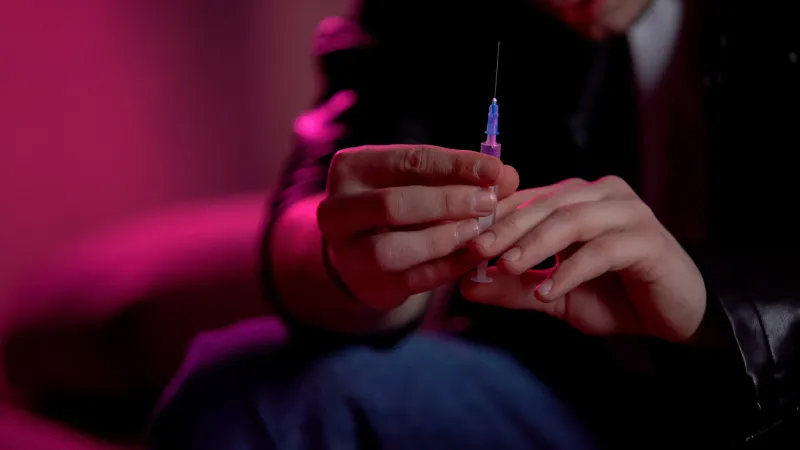 junky holding syringe, preparing to make injection, drug abuse problem concept