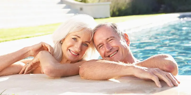 senior couple relaxing by outdoor pool together