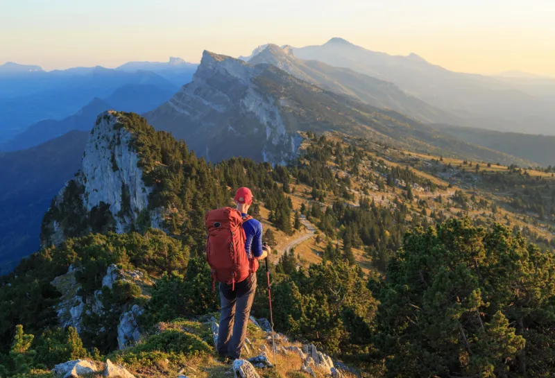 a hiker is looking over the mountains just before sunset les vercors, france