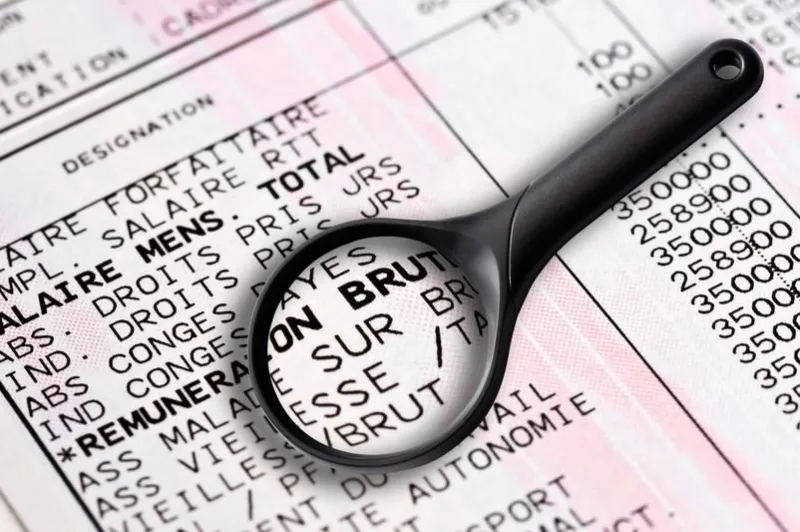 french payslip and magnifying glass close-up
