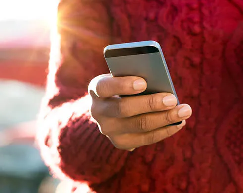 close up of a young woman's hand typing text message on her smartphone african young woman is typing on touch screen mobile phone close up of female hand texting a message phone outdoor