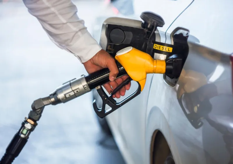 man hand holding yellow petrol pump, pump inside the car
