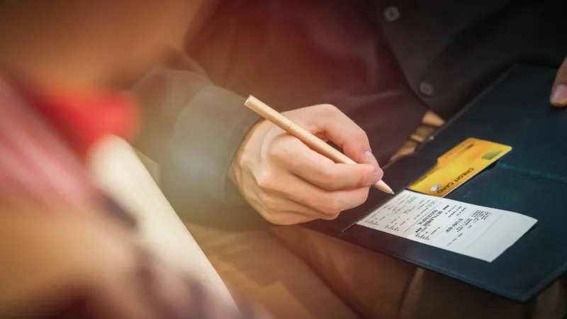 credit card payment bill and slip with hand holding pen ready to sign to make payment at shop