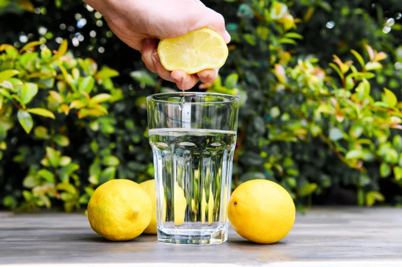 squeezing a lemon into the water cooking lemon water