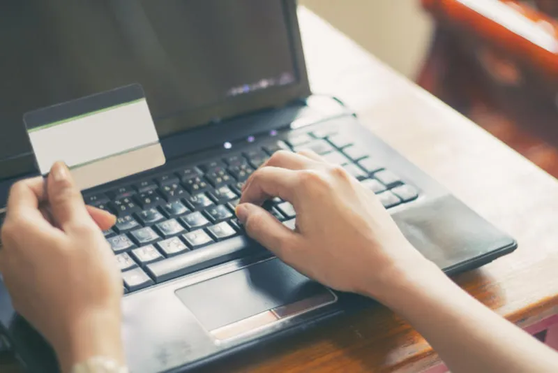 woman asian using laptop and credit card shopping online , selective focus on hand,soft focus and vintage tone
