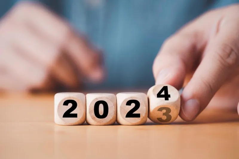 hand flipping of 2023 to 2024 on wooden block cube for preparation new year change and start new business target strategy concept
