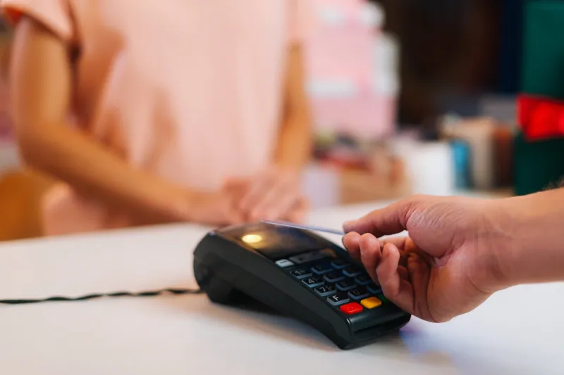 close-up view of unrecognizable male customer paying with nfc technology by credit card contactless on pos terminal, selective focus, blurred background contactless payment using debit card