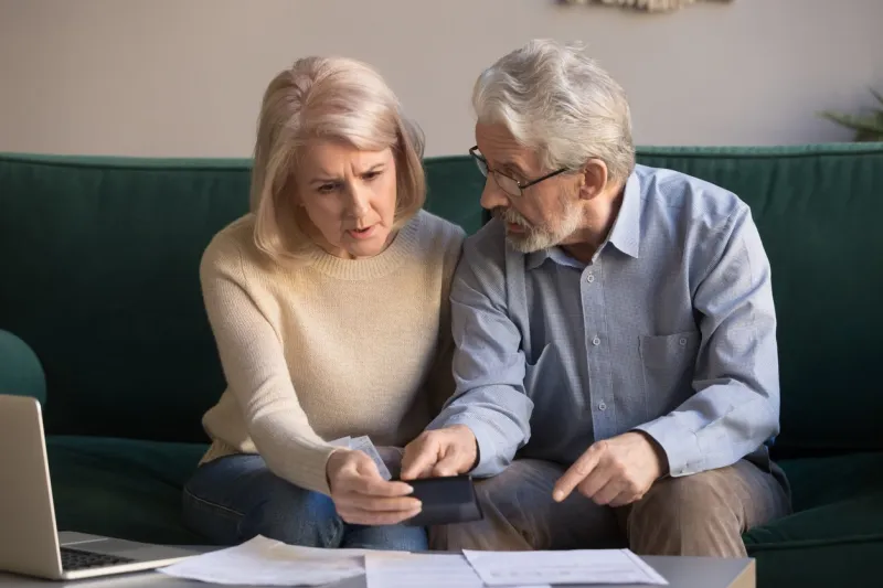 serious stressed senior old couple worried about paperwork discuss unpaid bank debt calculate bills, shocked poor retired family looking at calculator counting loan payment upset about money problem
