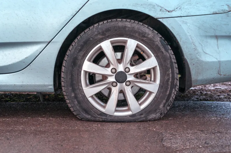 deflated tyre damage to blue car wheel