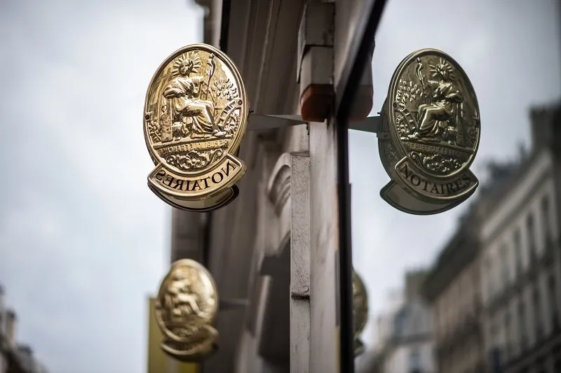 a picture taken on august 4, 2019 shows a notary sign on a building in paris (photo by martin bureau   afp)