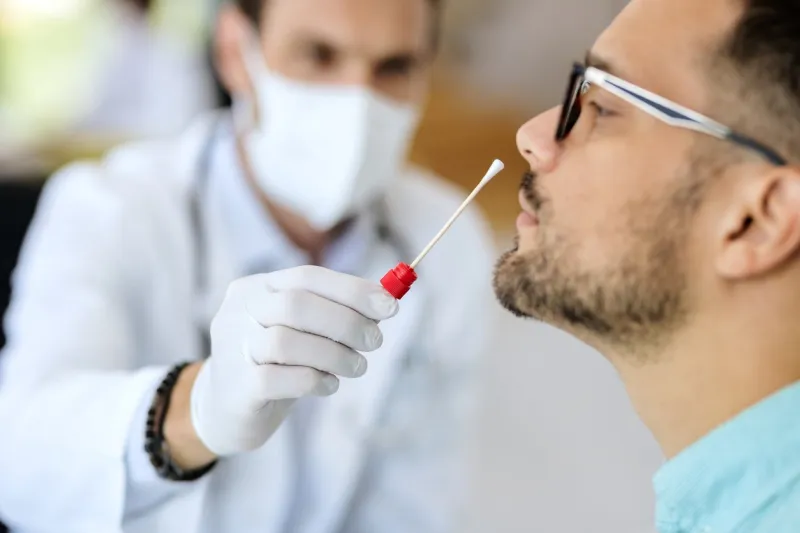 close-up of young man getting pcr test at doctor's office during coronavirus epidemic