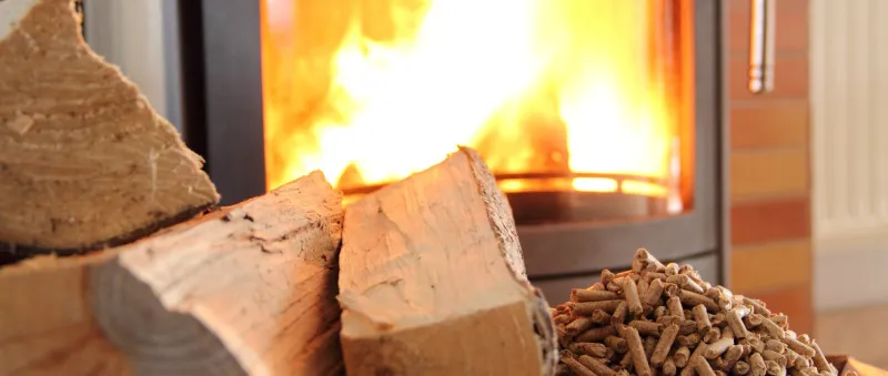 a burning fireplace stove with wood and pellets in the foreground