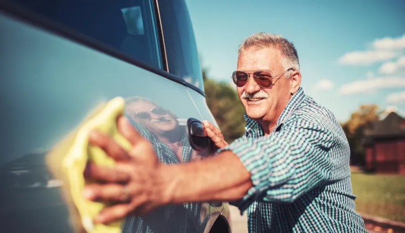 washing car senior man polishing his car with microfiber cloth
